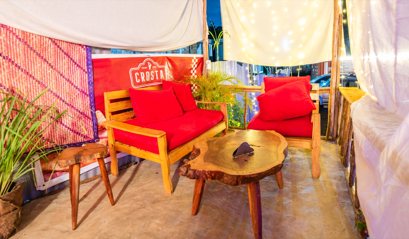 Red armchairs in the lounge corner under the canopy