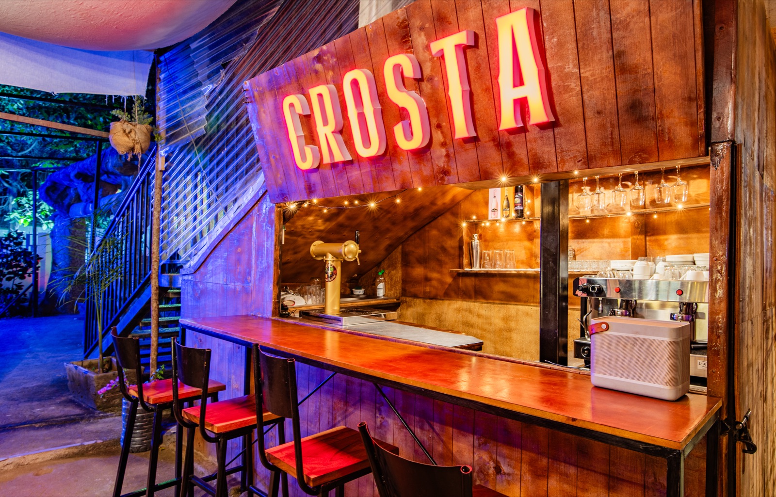 The bar counter at night with stools and string lights